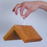 Elegante mangiatoia a casetta in legno chiaro per uccelli da giardino.